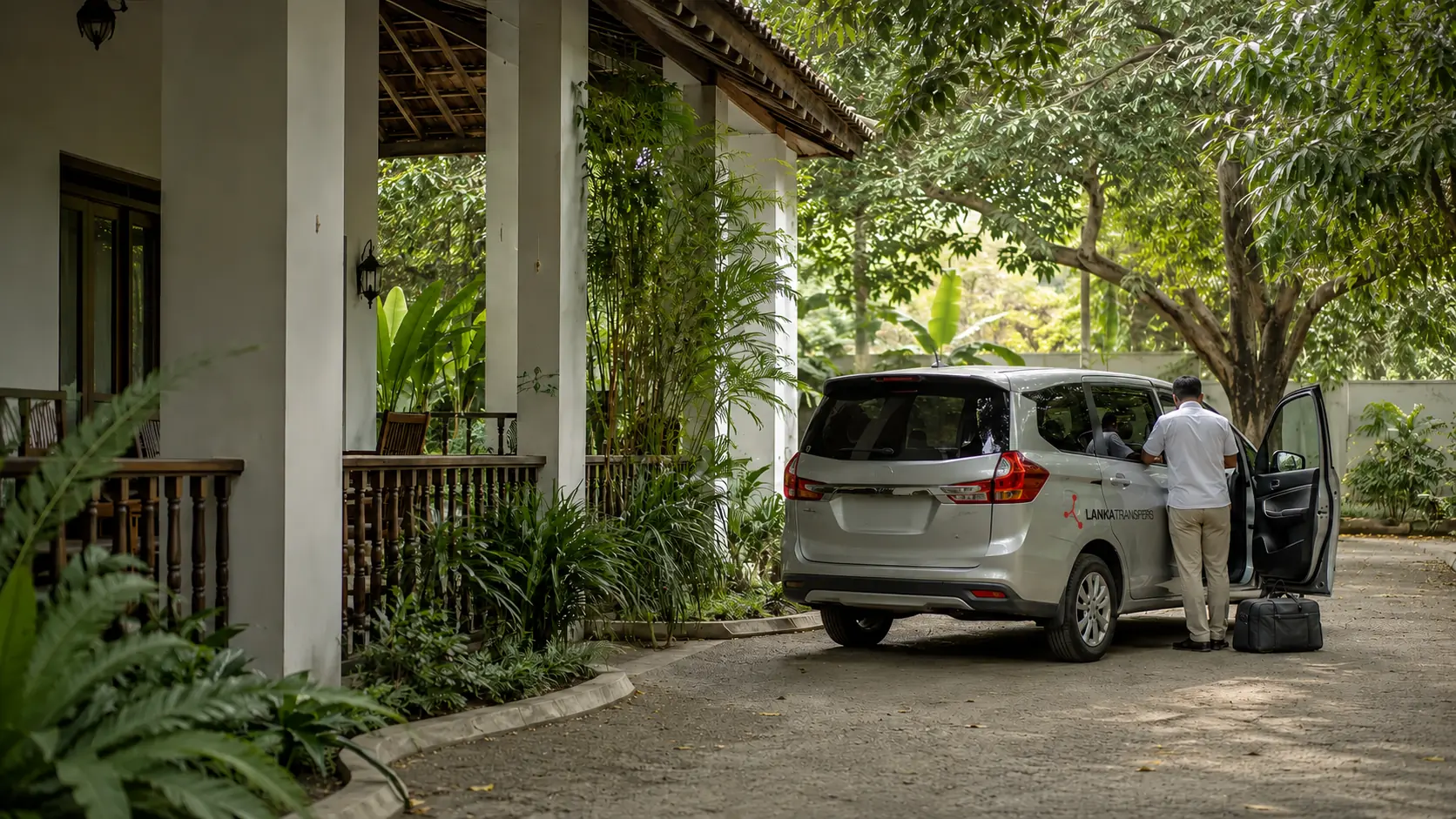 A professional driver preparing a private vehicle beside a Sri Lankan guesthouse