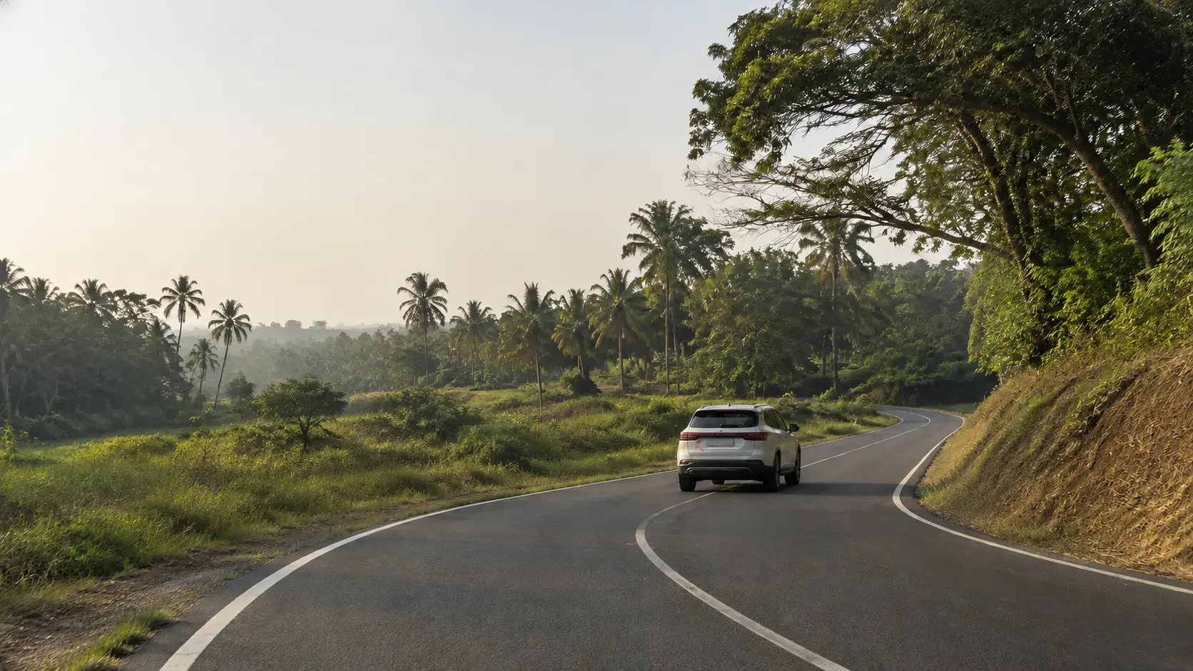 A private vehicle following a calm winding road through Sri Lanka